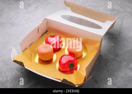 Fruchtmousse-Kuchen in Form von Erdbeeren und Pfirsich in einer Box Stockfoto