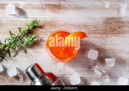 Orangencocktail und ein Shaker, mit Rosmarin und Eis, über dem Kopf flacher Lay Shot Stockfoto