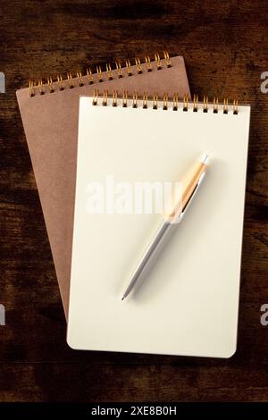 Notizbuchmodell mit Stift, oben auf einem Holztisch Stockfoto