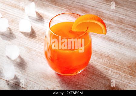 Orangengetränk auf hölzernem Hintergrund, frisch gepresster Saft mit Eis Stockfoto