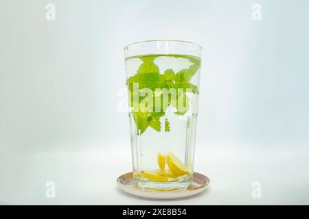 Ein Glas Minze Lemonade Wasser darin mit grünen Blättern isoliert kalte Zitrone Stockfoto