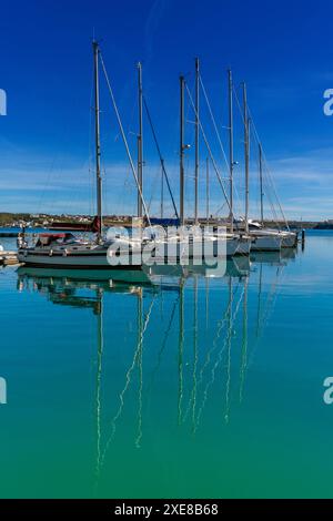 Vertikale Ansicht der vertäuten Segelboote im Hafen von Mahon auf Menorca mit Reflexionen im türkisfarbenen Wasser Stockfoto