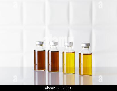 Gruppe von Glasflaschen mit injizierbarem Arzneimittel auf weißem Labortisch. Weißer Hintergrund. Stockfoto