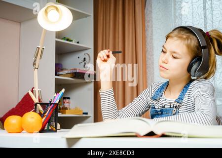 Teenager mit Kopfhörern und Schulaufgaben, Lern- und Studentenkonzept Stockfoto