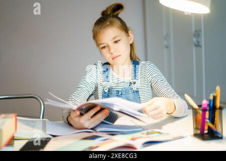 Schönes Mädchen, das zu Hause an ihrem Schulprojekt arbeitet, Bildungskonzept Stockfoto