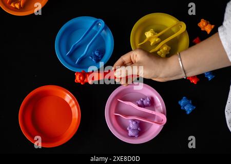 Entwicklung der Feinmotorik von Kindern mit Pinzetten und Kleinspielzeug Stockfoto