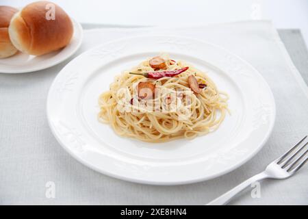 Spaghetti aglio olio Peperoncino mit Brot auf dem Tisch Stockfoto