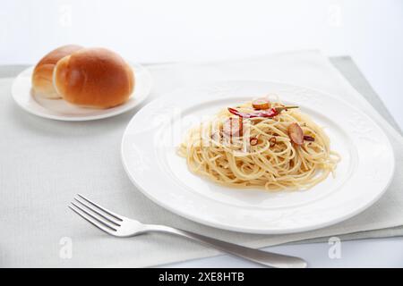 Spaghetti aglio olio Peperoncino mit Brot auf dem Tisch Stockfoto