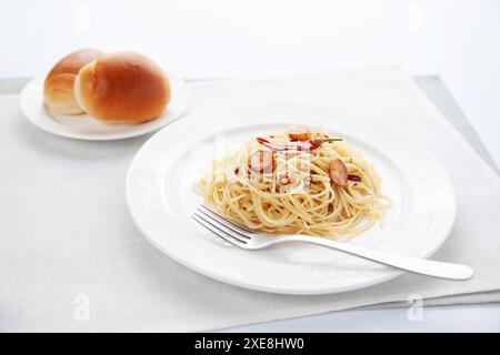 Spaghetti aglio olio Peperoncino mit Brot auf dem Tisch Stockfoto