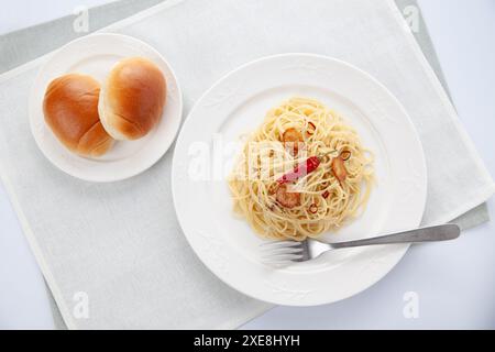 Spaghetti aglio olio Peperoncino mit Brot auf dem Tisch Stockfoto