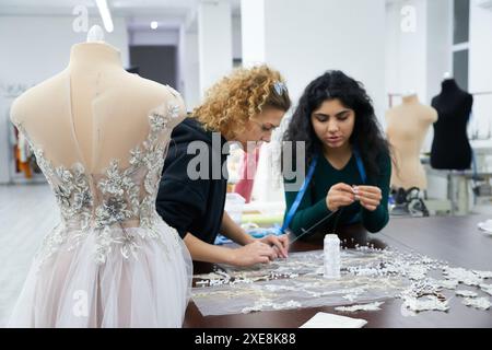 Eine Schaufensterpuppe mit einem Hochzeitskleid ist im Schneiderladen. Schneiderinnen in Atelier. Stockfoto