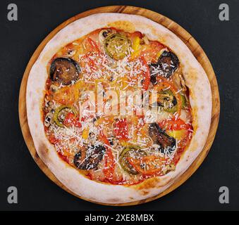 Vegane Pizza mit geröstetem Gemüse auf Holzbrett Stockfoto