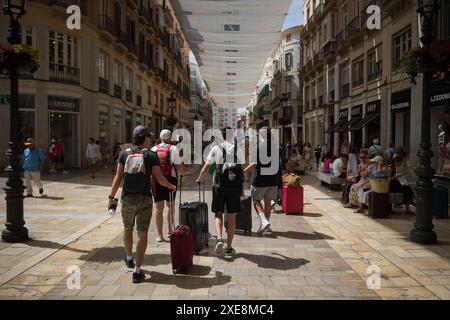 26. Juni 2024, Malaga, Spanien: Touristen werden in der Straße Marques de Larios gesehen, wie sie ihre Koffer schieben, vor dem Hintergrund der zunehmenden Ablehnung des Massentourismus. Malaga hat einen deutlichen Anstieg des Massentourismus und eine Zunahme der Zahl der Touristenwohnungen im Stadtzentrum und in den Vierteln erlebt. Diese Faktoren haben zu steigenden Miet- und Wohnungspreisen geführt. Lokale Nachbarschaftsverbände und -Organisationen fordern Maßnahmen zur Begrenzung der Mietpreise und der Auswirkungen des Massentourismus. (Credit Image: © Jesus Merida/SOPA images via ZUMA Press Wire) REDAKTIONELLE VERWENDUNG ONL Stockfoto