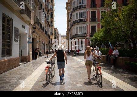 26. Juni 2024, Malaga, Spanien: Eine Gruppe von Touristen wird in einer Innenstadt mit ihren Fahrrädern auf einer Straße gesehen, die in einem Kontext der zunehmenden Ablehnung des Massentourismus läuft. Malaga hat einen deutlichen Anstieg des Massentourismus und eine Zunahme der Zahl der Touristenwohnungen im Stadtzentrum und in den Vierteln erlebt. Diese Faktoren haben zu steigenden Miet- und Wohnungspreisen geführt. Lokale Nachbarschaftsverbände und -Organisationen fordern Maßnahmen zur Begrenzung der Mietpreise und der Auswirkungen des Massentourismus. (Credit Image: © Jesus Merida/SOPA Images via ZUMA Press Wire Stockfoto