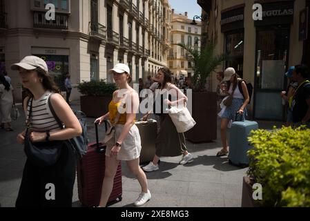 26. Juni 2024, Malaga, Spanien: Touristen werden gesehen, wie sie ihre Koffer auf einer Straße in der Innenstadt schieben, vor dem Hintergrund der zunehmenden Ablehnung des Massentourismus. Malaga hat einen deutlichen Anstieg des Massentourismus und eine Zunahme der Zahl der Touristenwohnungen im Stadtzentrum und in den Vierteln erlebt. Diese Faktoren haben zu steigenden Miet- und Wohnungspreisen geführt. Lokale Nachbarschaftsverbände und -Organisationen fordern Maßnahmen zur Begrenzung der Mietpreise und der Auswirkungen des Massentourismus. (Credit Image: © Jesus Merida/SOPA images via ZUMA Press Wire) REDAKTIONELLE VERWENDUNG AUF Stockfoto