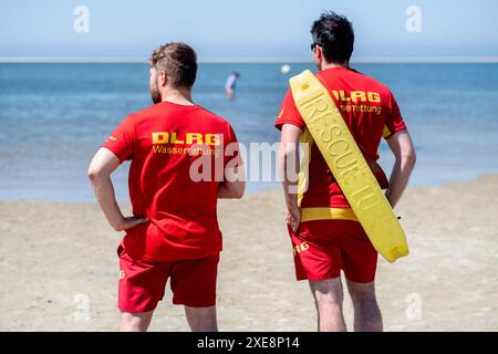 Borkum, Deutschland. Juni 2024. Zwei DLRG-Rettungsschwimmer beobachten bei sonnigem Wetter den Strand auf der Insel. Die Sommerferien in Niedersachsen begannen am 24.06.2024. Quelle: Hauke-Christian Dittrich/dpa/Alamy Live News Stockfoto