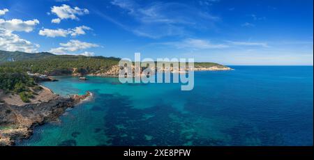 Die grüne und zerklüftete hügelige Küste von Nord-Ibiza mit Blick auf das türkisfarbene Wasser der Bucht Cala Xarraca Stockfoto