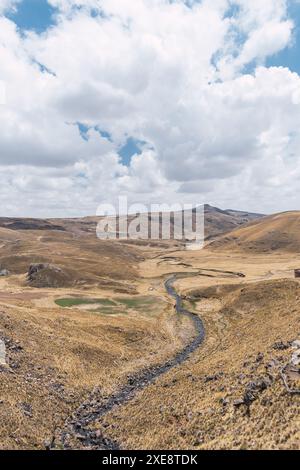 Schneebedeckte Landschaft der Berge in der Herbstsaison mit gelber Vegetation an einem sonnigen Tag mit Wolken und blauem Himmel Stockfoto