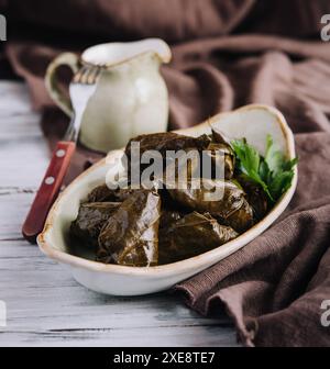 Dolma Kohl rollt Traubenblätter mit Füllung und weißer Soße Stockfoto