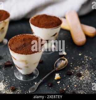 Italienisches Dessert Tiramisu im Glas und Eclairs mit Schokoladenscheiben Stockfoto