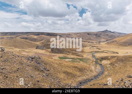 Schneebedeckte Landschaft der Berge in der Herbstsaison mit gelber Vegetation an einem sonnigen Tag mit Wolken und blauem Himmel Stockfoto