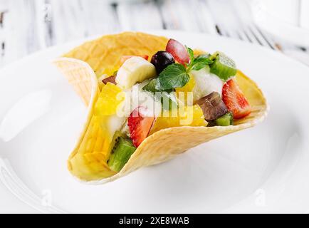 Zwei Messlöffel natürliches Bio-Fruchteis in einer Waffeltasse Stockfoto