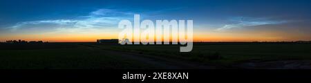 Atemberaubender Panoramablick auf eine helle Anzeige von NLC (NoctiLucent Clouds) über die niederländische Landschaft in einer Mittsommernacht. Stockfoto