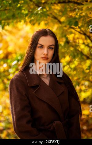 Porträt einer jungen Frau im braunen Mantel im Herbst Stockfoto