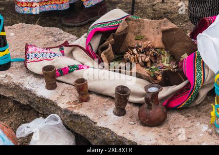 Traditionelles Ritual der Zahlung an die Erde mit Kokablättern und Chicha de jora in den Anden der Bergkette an einem sonnigen Tag Stockfoto