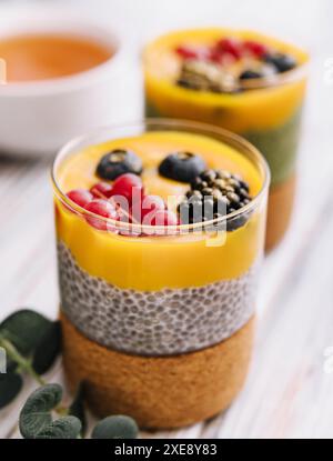 Gesunder veganer Chia-Pudding mit Mangohauce und frischen Beeren Stockfoto