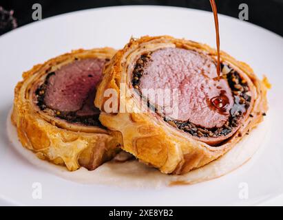 Filet wellington in Blätterteig auf Teller Stockfoto