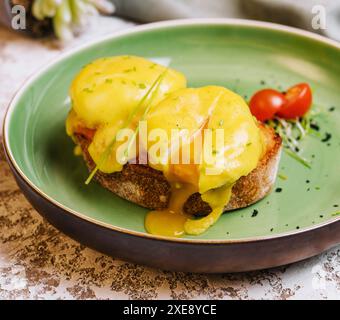 Klassisches Ei benedikt auf grünem Teller Stockfoto