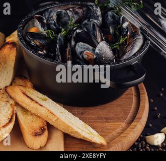 Traditionelles Barbecue italienische Blaumuschel in Weinsauce mit Baguettebrot Stockfoto