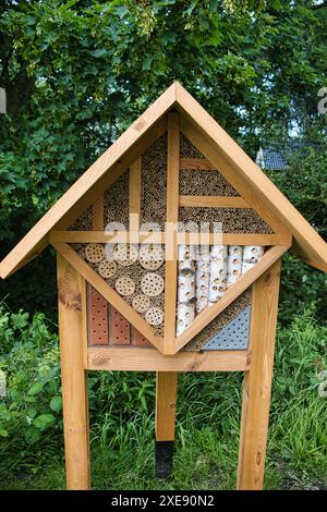 Wunderschön gefertigtes neues Holzinsektenhotel, das Bienen und anderen Insekten Zuflucht bietet Stockfoto