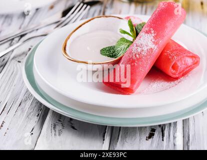 Gerollte Himbeerpfannkuchen mit Sauerrahm für Kinder Stockfoto