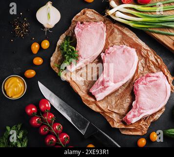 Mehrere rohe Schweinefleisch-Steaks auf Backpapier Stockfoto