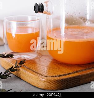 Heißes Getränk aus Sanddorn in einer Glasschale und Kanne Stockfoto