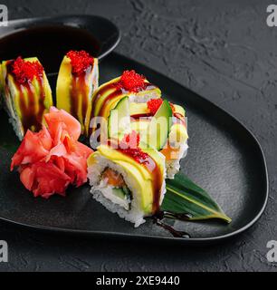 Grüne Drachen-Sushi-Rolle mit Aal auf schwarzem Stein Stockfoto