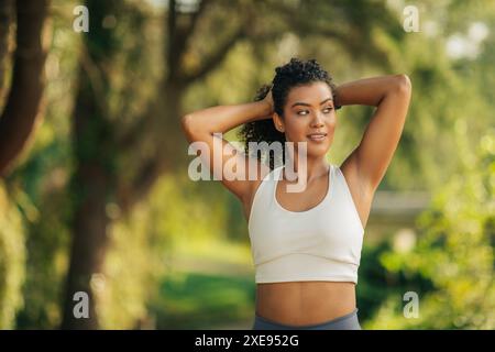 Frau im weißen Sport-BH, die ihr die Haare zubindet Stockfoto