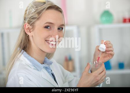 Wissenschaftler Tropfen Flüssigkeit aus der Pipette auf die Petrischale Stockfoto