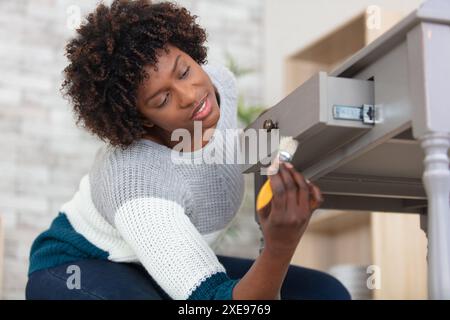 Nahaufnahme einer Frau, die Küchenschränke anmalt Stockfoto