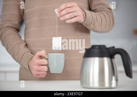 Nahaufnahme eines entspannten Mannes, der eine Tasse Tee hält Stockfoto