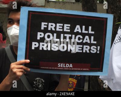 Manila, Philippinen. Juni 2024. Ein Demonstrant hält ein Plakat mit einem Slogan, der alle politischen Gefangenen während der Demonstration freilässt. SELDA (Vereinigung ehemaliger Häftlinge gegen Inhaftierung und Festnahme) ruft erneut dazu auf, die Folter einzustellen, alle Opfer und Überlebenden dieses abscheulichen Verbrechens zu bestrafen und alle politischen Gefangenen unter dem Regime von Präsident Marcos Jr. freizulassen. (Foto von Josefiel Rivera/SOPA Images/SIPA USA) Credit: SIPA USA/Alamy Live News Stockfoto