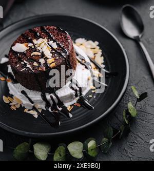 Teller mit frischen Brownies und Eis auf schwarzem Teller Stockfoto