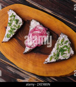 Brotstücke mit köstlichem Schmalz mit roten und grünen Zwiebeln Stockfoto