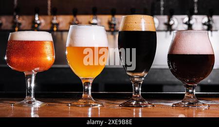 Verschiedene Arten von Craft-Bier in Gläsern auf dem Tisch im Pub-Innenraum Stockfoto