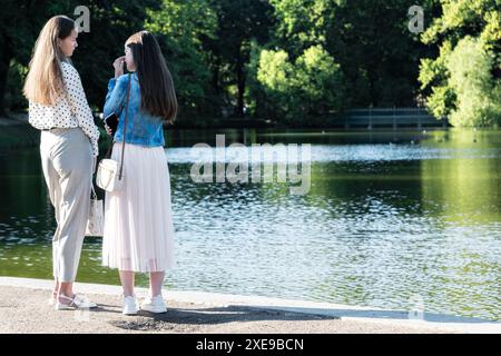 St. Petersburg, Russland, 20. August: Zwei junge Mädchen kommunizieren miteinander im Tauridgarten, der am Ufer eines Teichs in St. Petersbur steht Stockfoto