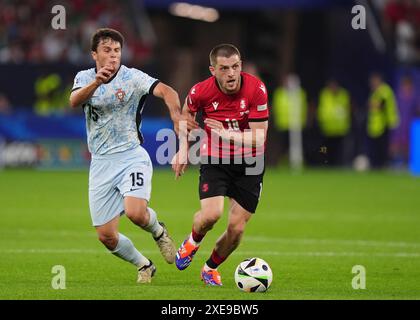 Georgiens Giorgi Chakvetadze im Kampf gegen den Portugiesen Joao Neves während des Gruppenspiels der UEFA Euro 2024 in der Arena AufSchalke in Gelsenkirchen. Bilddatum: Mittwoch, 26. Juni 2024. Stockfoto