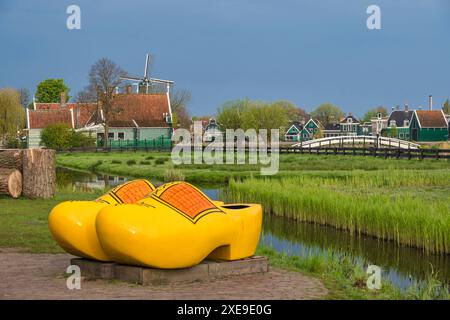 Zaanse Schans, Niederlande - 1. Mai 2023: Niederländische Windmühle und traditionelles Haus mit Holzschuhen im Dorf Stockfoto