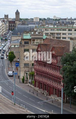 Caen, Frankreich - 21. Juli 2017: Fachwerkhaus, bekannt als „Maison des Quatrans“ und mit dahinter der „Eglise Saint Jean“. Stockfoto